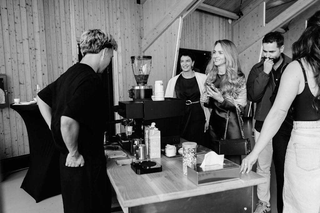 A BRÚW barista serving guests at the mobile coffee bar